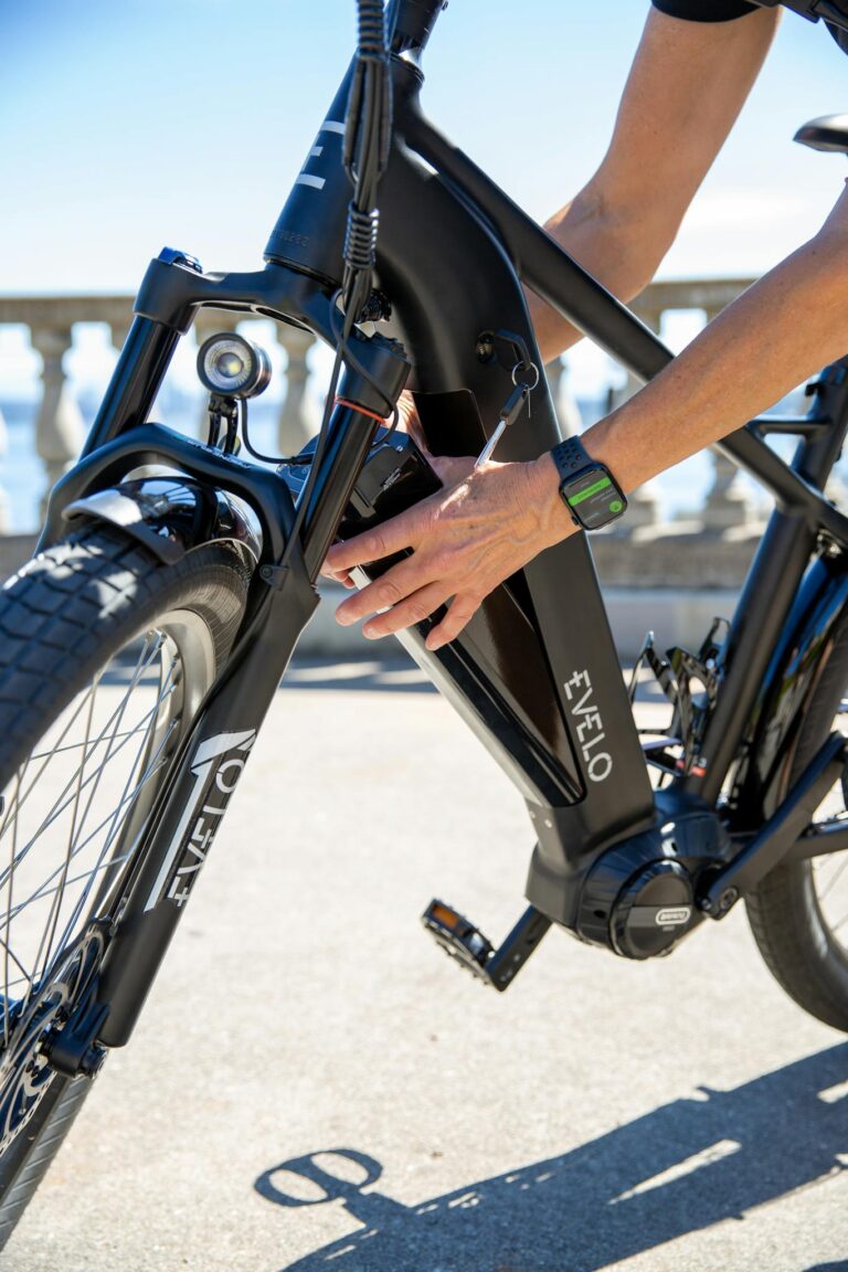 Person adjusting Evelo electric bike on a sunny day, showcasing modern cycling technology.